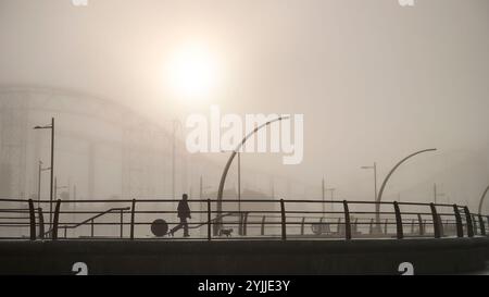 Mann, der Hund in dickem Nebel an der Küste von Blackpool läuft Stockfoto