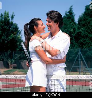 Lifestyle. Sport. Ein junges Paar, das sich auf dem Tennisplatz umschließt. Stockfoto