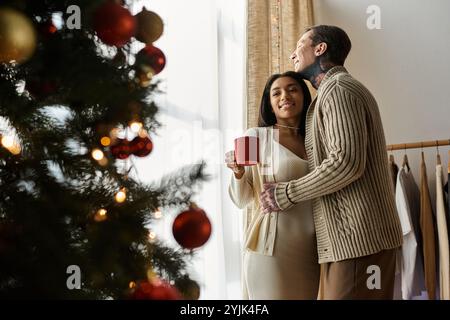 Dieses liebevolle Paar genießt die Gesellschaft, während es die Freude an Weihnachten zu Hause feiert. Stockfoto