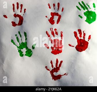 Handabdrücke auf Papier, Farbe rot und grün, natürliche Textur Stockfoto