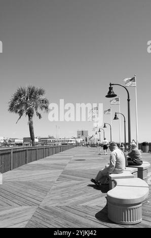 Touristen, die sich auf der neuen Promenade in Myrtle Beach, SC, USA, entspannen. Der Holzsteg erstreckt sich über den Grand Strand und wurde 2010 fertiggestellt. Stockfoto