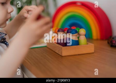 Ein Montessori-Kind spielerisches Lernen durch engagierte bunte hölzerne Sensorik blockiert lehrreiches Spielzeug kognitive kreative Fähigkeiten. Stockfoto