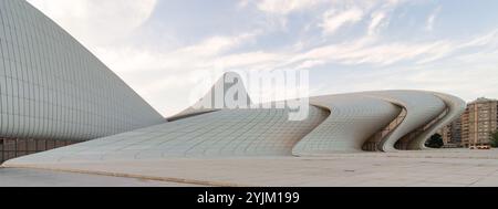 Das ikonische Heydar Aliyev Centre in Baku, Aserbaidschan, zeigt moderne Architektur mit seinem fließenden, wellenartigen Design vor einem bewölkten Himmel vor Sonnenuntergang. Entworfen von der Architektin Zaha Hadid Stockfoto