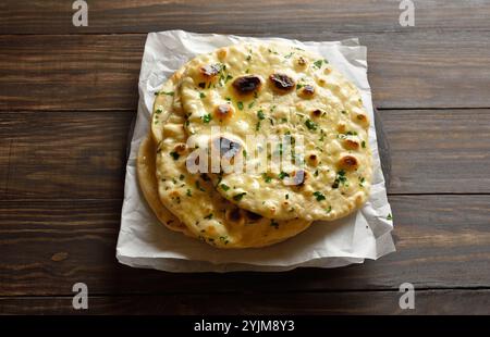 Hausgemachtes indisches Naan-Brot mit Knoblauchbutter auf Holztisch. Nahansicht Stockfoto