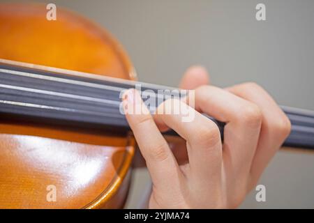 Spielen Sie mit der linken Hand Geige. Korrekte Positionierung von Hand und Fingern auf einem Musikinstrument Stockfoto