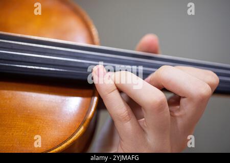 Spielen Sie mit der linken Hand Geige. Korrekte Positionierung von Hand und Fingern auf einem Musikinstrument Stockfoto