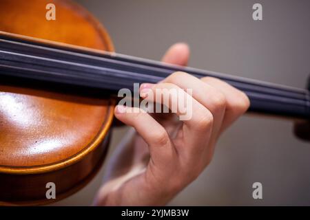 Spielen Sie mit der linken Hand Geige. Korrekte Positionierung von Hand und Fingern auf einem Musikinstrument Stockfoto