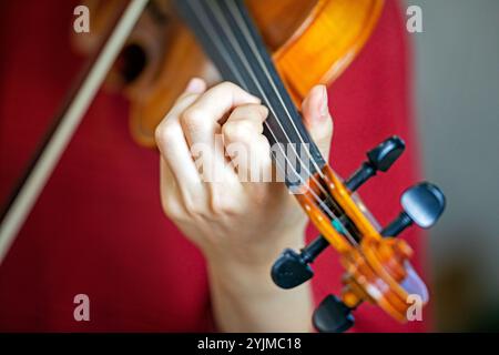 Spielen Sie mit der linken Hand Geige. Korrekte Positionierung von Hand und Fingern auf einem Musikinstrument Stockfoto