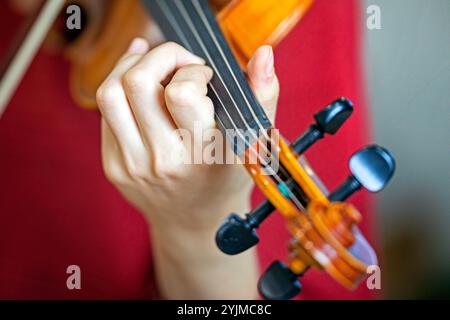 Spielen Sie mit der linken Hand Geige. Korrekte Positionierung von Hand und Fingern auf einem Musikinstrument Stockfoto