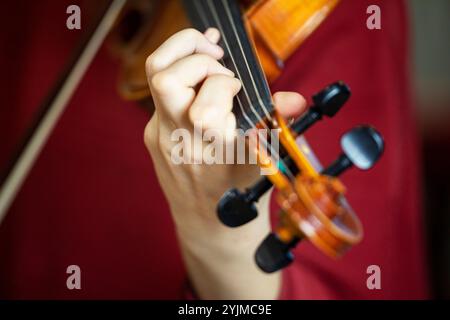 Spielen Sie mit der linken Hand Geige. Korrekte Positionierung von Hand und Fingern auf einem Musikinstrument Stockfoto