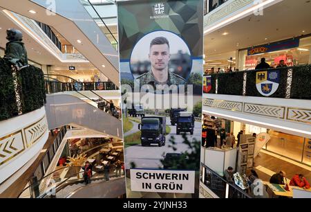 Schwerin, Deutschland. November 2024. In der Marienplatz-Galerie hängen große Banner der Bundeswehr, die auf die Kampagne "Schwerin in Grün" hinweisen. Vom 11. Bis 16.11.2024 präsentierten sich rund 20 Zweige der Bundeswehr aus Armee, Luftwaffe und Marine im Einkaufszentrum mit verschiedenen Infoständen und Aktivitäten. Quelle: Bernd Wüstneck/dpa/Alamy Live News Stockfoto