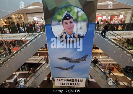 Schwerin, Deutschland. November 2024. In der Marienplatz-Galerie hängen große Banner der Bundeswehr, die auf die Kampagne "Schwerin in Grün" hinweisen. Vom 11. Bis 16.11.2024 präsentierten sich rund 20 Zweige der Bundeswehr aus Armee, Luftwaffe und Marine im Einkaufszentrum mit verschiedenen Infoständen und Aktivitäten. Quelle: Bernd Wüstneck/dpa/Alamy Live News Stockfoto