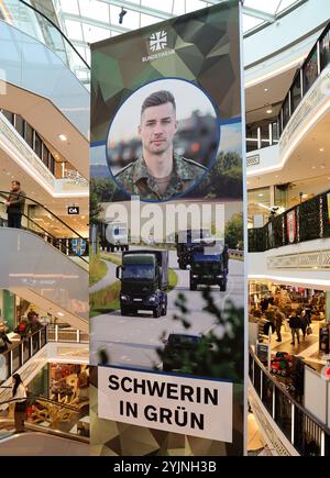 Schwerin, Deutschland. November 2024. In der Marienplatz-Galerie hängen große Banner der Bundeswehr, die auf die Kampagne "Schwerin in Grün" hinweisen. Vom 11. Bis 16.11.2024 präsentierten sich rund 20 Zweige der Bundeswehr aus Armee, Luftwaffe und Marine im Einkaufszentrum mit verschiedenen Infoständen und Aktivitäten. Quelle: Bernd Wüstneck/dpa/Alamy Live News Stockfoto