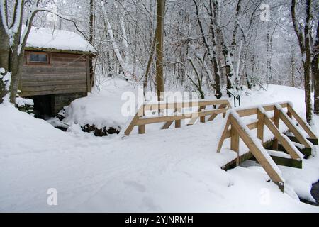 Einzigartiges Holzhaus mit Schnee über einem kleinen Bach mit fließendem Wasser gebaut. Rogaland Norwegen Stockfoto