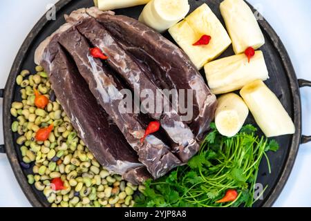 Traditionelles rustikales, tropisches brasilianisches Gericht, sonnengetrocknetes Rindfleisch mit grünen Bohnen, Maniok, Biquinho-Pfeffer. Kreative rustikale Fotografie Stockfoto