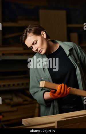 Eine gelernte Schreinerin konzentriert sich intensiv auf das Formen von Holz und zeigt handwerkliches Können in ihrer Werkstatt. Stockfoto