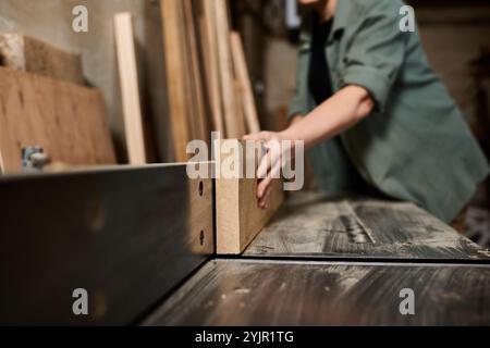Eine gelernte Schreinerin konzentriert sich intensiv auf die Holzherstellung in ihrer Werkstatt und zeigt handwerkliches Können und Hingabe. Stockfoto