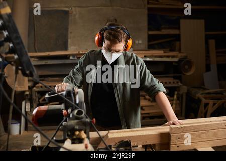 Ein erfahrener Zimmermann arbeitet fleißig mit Holz und zeigt handwerkliches Können in einer gut ausgestatteten Werkstatt. Stockfoto