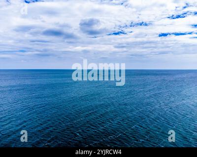 Ein Blick auf das Meer in Richtung eines entfernten Mulberry Harbour Wracks in Pagham, Sussex im Sommer Stockfoto