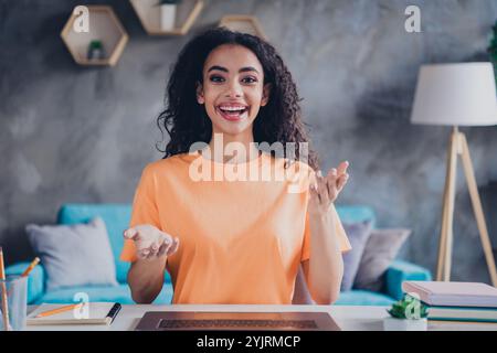 Junge Frau, die von zu Hause aus in einem hellen Zimmer mit stilvoller Einrichtung und gemütlicher Atmosphäre studiert. Stockfoto
