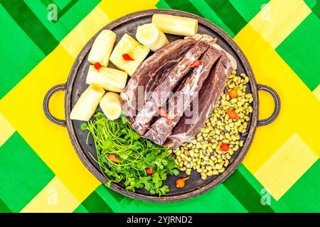 Traditionelles rustikales, tropisches brasilianisches Gericht, sonnengetrocknetes Rindfleisch mit grünen Bohnen, Maniok, Biquinho-Pfeffer. Kreative rustikale Fotografie Stockfoto