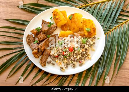 Traditionelles rustikales, tropisches brasilianisches Gericht, sonnengetrocknetes Rindfleisch mit grünen Bohnen, Maniok, Biquinho-Pfeffer. Kreative rustikale Fotografie Stockfoto