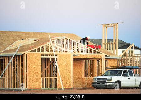 Apache Junction, Arizona, USA. November 2024. Der Boom des Wohnungsbaus im Pinal County, Arizona, verwandelt einst dünn besiedelte Gebiete schnell in neue Wohnsiedlungen. Bauarbeiter arbeiten lange Zeit, um die steigende Nachfrage nach erschwinglichem Wohnraum zu befriedigen, da sich die Unterteilungen erweitern, um der wachsenden Bevölkerung des Countys gerecht zu werden. Die Entwickler verweisen auf Arizonas starkes Wirtschaftswachstum und relativ erschwingliches Land in Pinal als Schlüsselfaktoren. Projekte versprechen eine Mischung aus Einfamilienhäusern, Stadthäusern und Annehmlichkeiten, um lokale und außerstaatliche Käufer anzuziehen. (Kredit-Imag Stockfoto