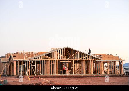 Apache Junction, Arizona, USA. November 2024. Der Boom des Wohnungsbaus im Pinal County, Arizona, verwandelt einst dünn besiedelte Gebiete schnell in neue Wohnsiedlungen. Bauarbeiter arbeiten lange Zeit, um die steigende Nachfrage nach erschwinglichem Wohnraum zu befriedigen, da sich die Unterteilungen erweitern, um der wachsenden Bevölkerung des Countys gerecht zu werden. Die Entwickler verweisen auf Arizonas starkes Wirtschaftswachstum und relativ erschwingliches Land in Pinal als Schlüsselfaktoren. Projekte versprechen eine Mischung aus Einfamilienhäusern, Stadthäusern und Annehmlichkeiten, um lokale und außerstaatliche Käufer anzuziehen. (Kredit-Imag Stockfoto