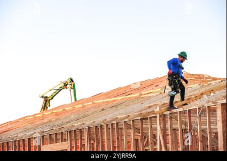 Apache Junction, Arizona, USA. November 2024. Der Boom des Wohnungsbaus im Pinal County, Arizona, verwandelt einst dünn besiedelte Gebiete schnell in neue Wohnsiedlungen. Bauarbeiter arbeiten lange Zeit, um die steigende Nachfrage nach erschwinglichem Wohnraum zu befriedigen, da sich die Unterteilungen erweitern, um der wachsenden Bevölkerung des Countys gerecht zu werden. Die Entwickler verweisen auf Arizonas starkes Wirtschaftswachstum und relativ erschwingliches Land in Pinal als Schlüsselfaktoren. Projekte versprechen eine Mischung aus Einfamilienhäusern, Stadthäusern und Annehmlichkeiten, um lokale und außerstaatliche Käufer anzuziehen. (Kredit-Imag Stockfoto