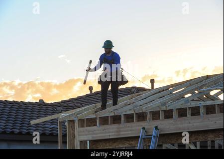 Apache Junction, Arizona, USA. November 2024. Der Boom des Wohnungsbaus im Pinal County, Arizona, verwandelt einst dünn besiedelte Gebiete schnell in neue Wohnsiedlungen. Bauarbeiter arbeiten lange Zeit, um die steigende Nachfrage nach erschwinglichem Wohnraum zu befriedigen, da sich die Unterteilungen erweitern, um der wachsenden Bevölkerung des Countys gerecht zu werden. Die Entwickler verweisen auf Arizonas starkes Wirtschaftswachstum und relativ erschwingliches Land in Pinal als Schlüsselfaktoren. Projekte versprechen eine Mischung aus Einfamilienhäusern, Stadthäusern und Annehmlichkeiten, um lokale und außerstaatliche Käufer anzuziehen. (Kredit-Imag Stockfoto