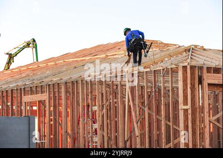 Apache Junction, Arizona, USA. November 2024. Der Boom des Wohnungsbaus im Pinal County, Arizona, verwandelt einst dünn besiedelte Gebiete schnell in neue Wohnsiedlungen. Bauarbeiter arbeiten lange Zeit, um die steigende Nachfrage nach erschwinglichem Wohnraum zu befriedigen, da sich die Unterteilungen erweitern, um der wachsenden Bevölkerung des Countys gerecht zu werden. Die Entwickler verweisen auf Arizonas starkes Wirtschaftswachstum und relativ erschwingliches Land in Pinal als Schlüsselfaktoren. Projekte versprechen eine Mischung aus Einfamilienhäusern, Stadthäusern und Annehmlichkeiten, um lokale und außerstaatliche Käufer anzuziehen. (Kredit-Imag Stockfoto