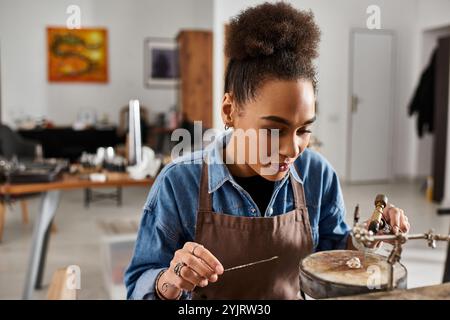 Die talentierte Frau bastelt in ihrem künstlerischen Schmuckstudio mit Präzision schöne Stücke. Stockfoto