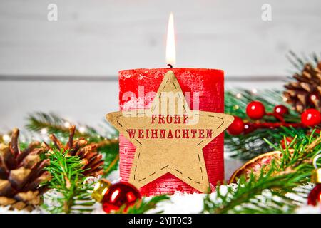 Bayern, Deutschland - 14. November 2024: Rote Kerze mit einem Holzstern mit dem Schriftzug FROHE WEIHNACHTEN umgeben von Tannenzweigen, Kegeln und Weihnachtsdekorationen. FOTOMONTAGE *** Rote Kerze mit einem Holzstern mit dem Schriftzug: FROHE WEIHNACHTEN umgeben von Tannenzweigen, Zapfen und weihnachtliche Dekoration. FOTOMONTAGE Stockfoto