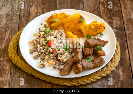 Traditionelles rustikales, tropisches brasilianisches Gericht, sonnengetrocknetes Rindfleisch mit grünen Bohnen, Maniok, Biquinho-Pfeffer. Kreative rustikale Fotografie Stockfoto