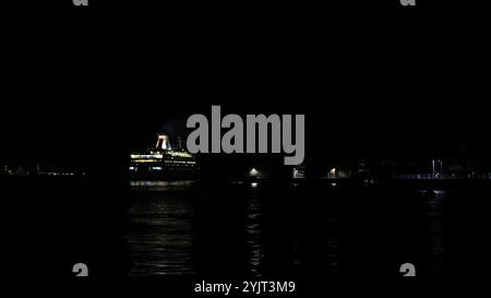 Portsmouth, Hampshire, England. 31. Oktober 2024. Halloween-Nacht: Weitwinkelblick einer Roll-on-Roll-off-Fähre, die in den Hafen einfährt. Stockfoto