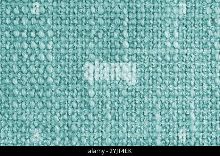 Textur von türkisfarbenem Jacquard-Gewebe aus rauem Gewebe, Stoffstrukturhintergrund, Nahaufnahme, Makro. Material für Heimtextilien, Polster und Vorhänge DE Stockfoto