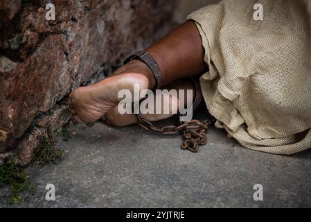 Detail der geketteten Füße einer schwarzen Frau in Pelourinho. Sklaverei in Brasilien. Darstellung der Sklavin Anastacia. Stockfoto