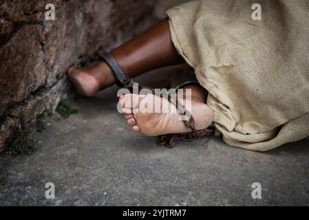 Detail der geketteten Füße einer schwarzen Frau in Pelourinho. Sklaverei in Brasilien. Darstellung der Sklavin Anastacia. Stockfoto