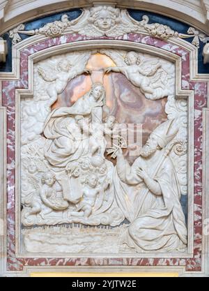 PAVIA, ITALIEN - 8. SEPTEMBER 2024: Das Marmorrelief der Madonna mit dem Heiligen Sirus in der Kathedrale von Tommaso Orsolino (1587–1675). Stockfoto