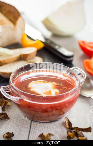 Fastenborsch mit getrockneten Pilzen und Gemüse auf einem hellen Holztisch. Stockfoto