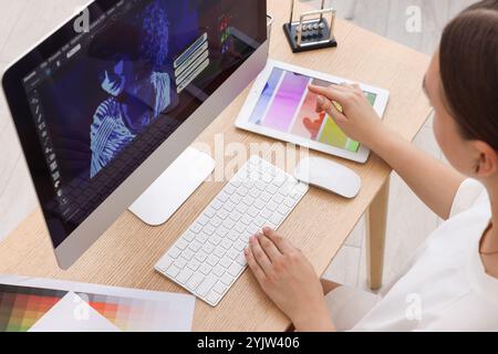 Designer, der am Computer am Holztisch arbeitet Stockfoto