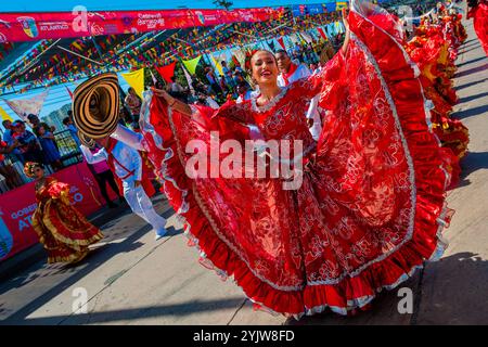 Kolumbianische Paare, die traditionelle Cumbia-Outfits tragen, tanzen die Cumbia während der Parade des Karnevals in Barranquilla, Kolumbien. Stockfoto