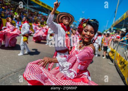 Afro-kolumbianische Paare, die traditionelle Cumbia-Outfits tragen, tanzen die Cumbia während der Parade des Karnevals in Barranquilla, Kolumbien. Stockfoto