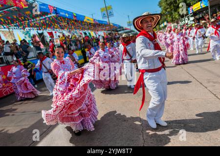 Kolumbianische Paare, die traditionelle Cumbia-Outfits tragen, tanzen die Cumbia während der Parade des Karnevals in Barranquilla, Kolumbien. Stockfoto