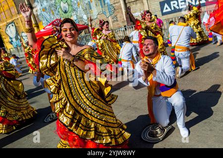 Kolumbianische Paare, die traditionelle Cumbia-Outfits tragen, tanzen die Cumbia während der Parade des Karnevals in Barranquilla, Kolumbien. Stockfoto