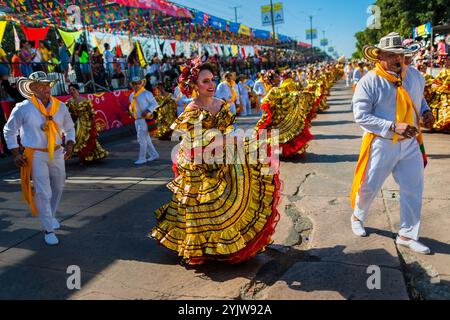 Kolumbianische Paare, die traditionelle Cumbia-Outfits tragen, tanzen die Cumbia während der Parade des Karnevals in Barranquilla, Kolumbien. Stockfoto