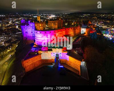 Edinburgh, Schottland, Großbritannien. November 2024. Luftaufnahme von Edinburgh Castle, beleuchtet mit farbigen Scheinwerfern. Iain Masterton/Alamy Live News Stockfoto