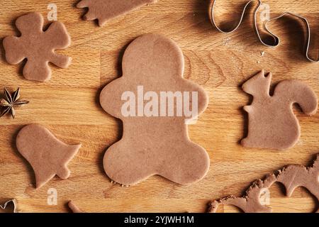 Lebkuchenmann schneidet uns aus rohem Teig - Zubereitung von selbstgemachten Weihnachtskeksen Stockfoto