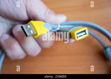 USB-Kabel in der Hand eines Mannes Nahaufnahme. Stockfoto