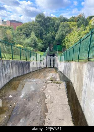 Manchester, UK, 4. Oktober 2024. Der Überlauf vom Gorton Lower Reservoir mit einem verlassenen Eisenbahntunnel neben dem Flood Control Debdale Park Manchester Stockfoto